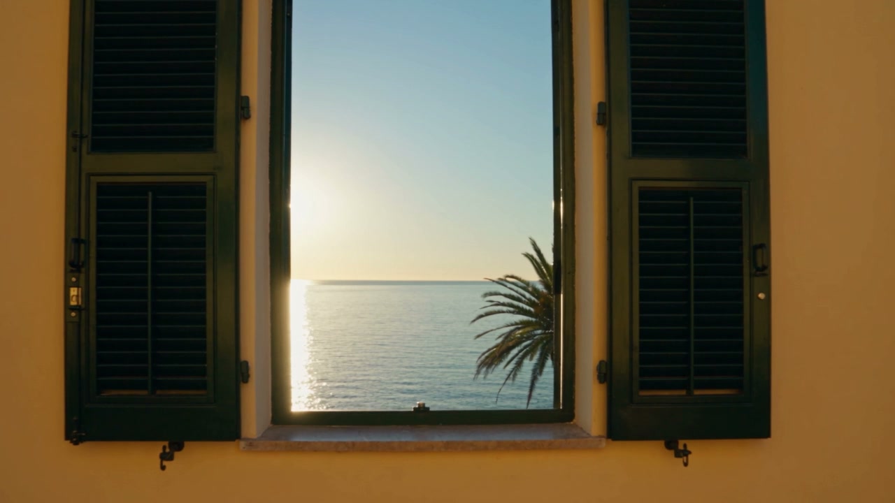 A window with green shutters open onto the sea of Rapallo at dawn, with a palm tree